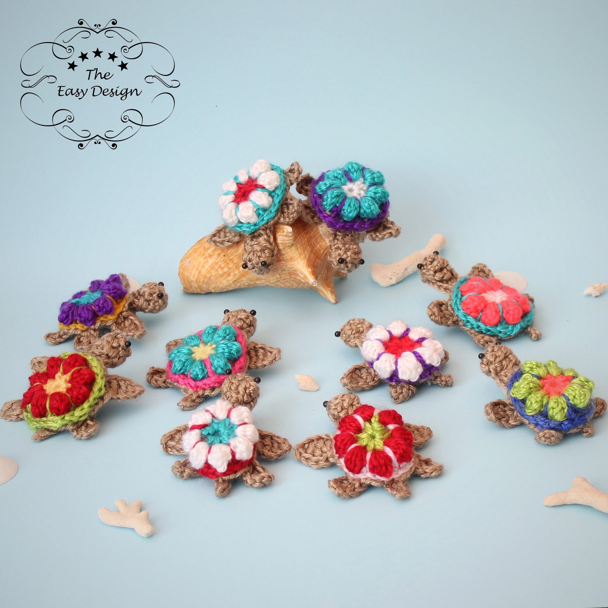 May include: Nine crocheted turtle ornaments with colorful flower designs on their shells. The turtles are arranged on a light blue background.