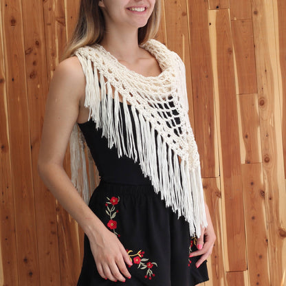 May include: A white crochet shawl with fringe, worn over a black dress with red floral embroidery.