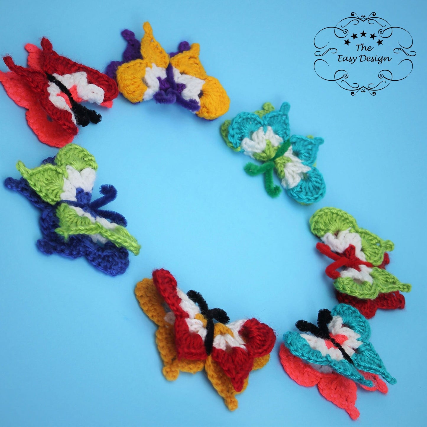 May include: A set of seven crocheted butterflies in various colors, including red, white, blue, green, yellow, and purple. The butterflies are arranged in a circle on a blue background.