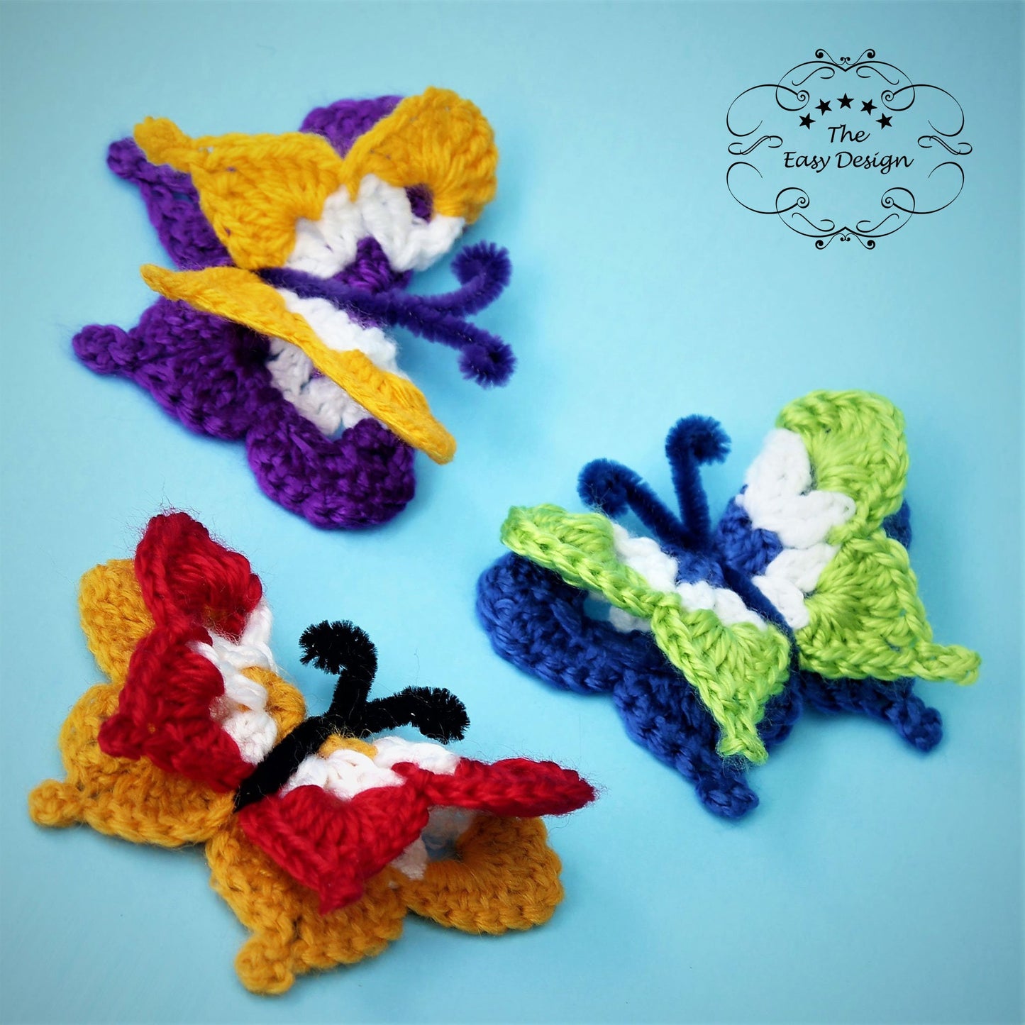 May include: Three crocheted butterflies in different colors: purple, yellow, and white; blue, green, and white; and red, white, and yellow. The butterflies have pipe cleaner antennas.
