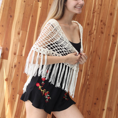 May include: White crochet shawl with fringe trim. The shawl is made of a delicate, open-weave fabric and has a scalloped edge. The fringe is long and flowing, adding a touch of bohemian style.