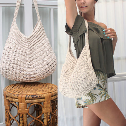 May include: Cream-colored, crochet shoulder bag with a textured pattern. The bag has a wide, open top and a long strap. The bag is shown hanging and being worn. The bag is made of a soft, natural fiber.