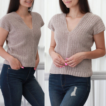 May include: A beige crochet top with a v-neck and short sleeves. The top is made with a loose, open stitch pattern. The model is wearing blue jeans.