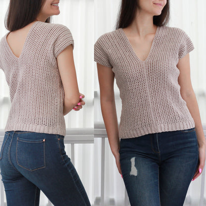 May include: A beige crochet top with a V-neck and short sleeves. The top is made of a lightweight, breathable fabric and has a relaxed fit. The model is wearing the top with blue jeans.