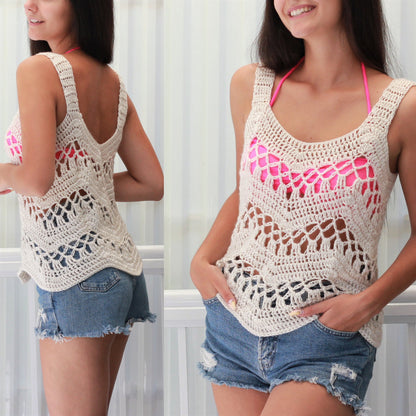 May include: A crocheted tank top with a delicate openwork pattern. The top is cream colored and has a scoop neck. The model is wearing the top with denim shorts.