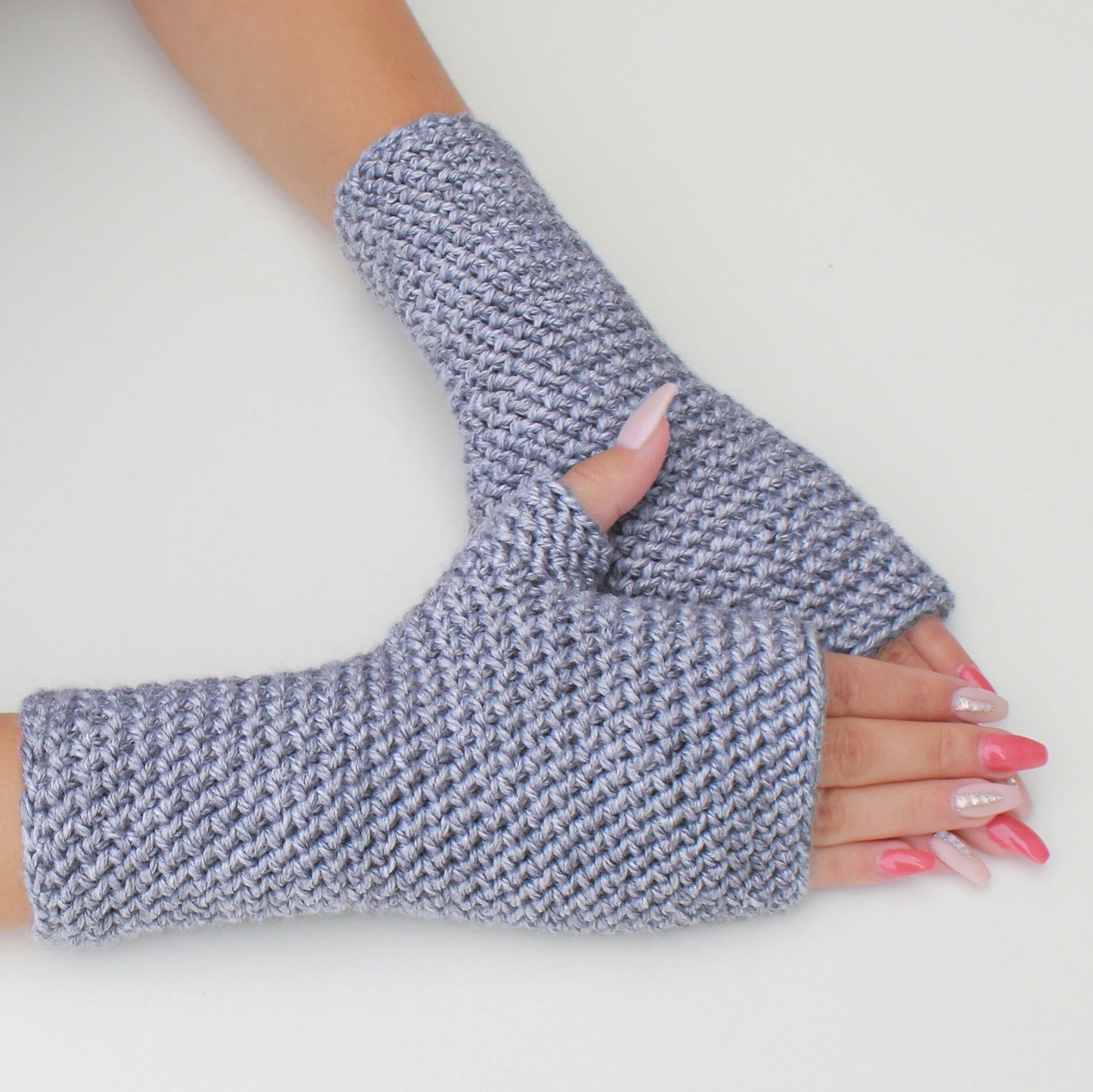 May include: A pair of gray fingerless gloves with a textured knit pattern. The gloves are made of a soft, warm material and are perfect for keeping your hands warm in the winter.