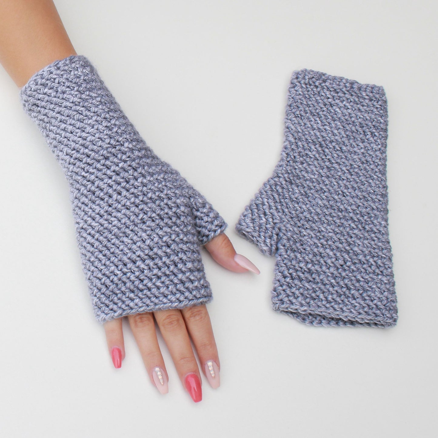 May include: A pair of gray fingerless gloves with a textured knit pattern. The gloves are shown on a white background.