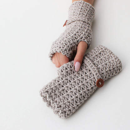 May include: A pair of beige crocheted fingerless gloves with a wooden button on one glove.