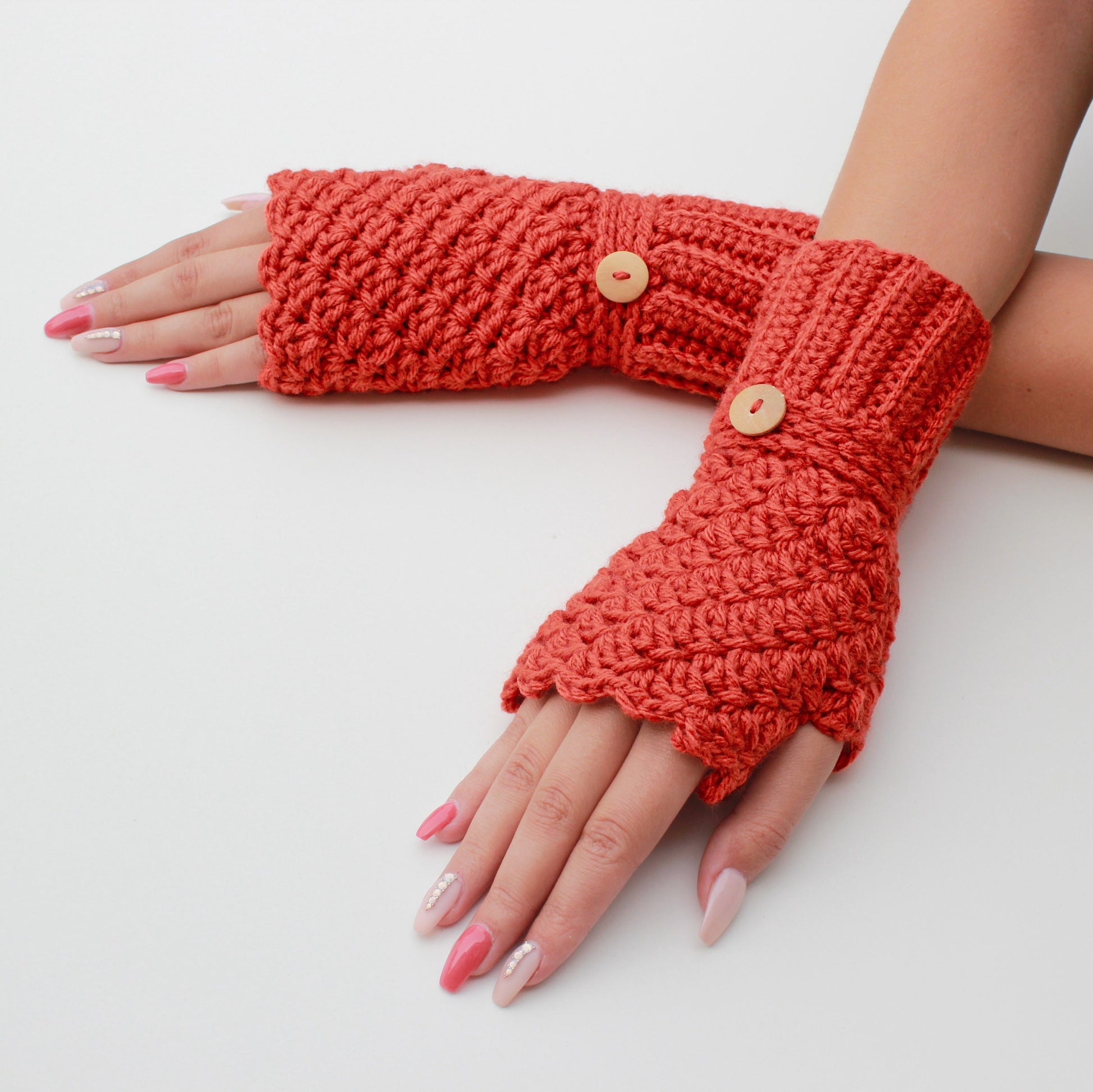 May include: A pair of orange crocheted fingerless gloves with wooden buttons.