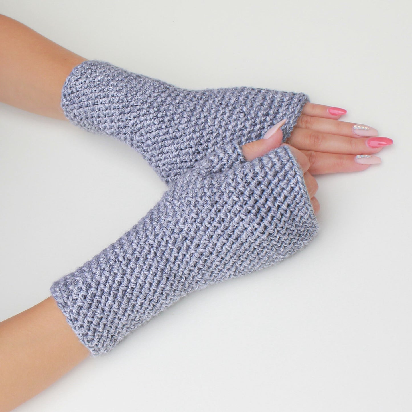 May include: A pair of gray fingerless gloves made of a textured knit fabric.
