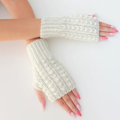 May include: A pair of white crocheted fingerless gloves with a textured design. The gloves are made with a chunky yarn and have a simple, elegant style.