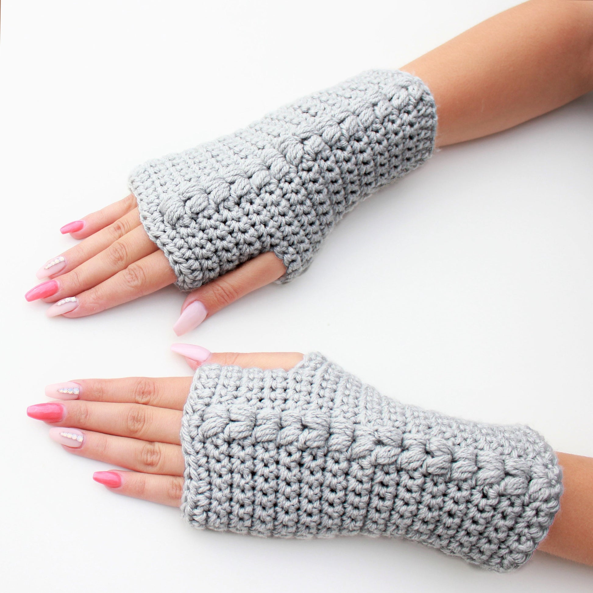May include: A pair of gray fingerless gloves with a textured knit pattern. The gloves are made of a soft, warm yarn and are perfect for keeping your hands warm in the winter.