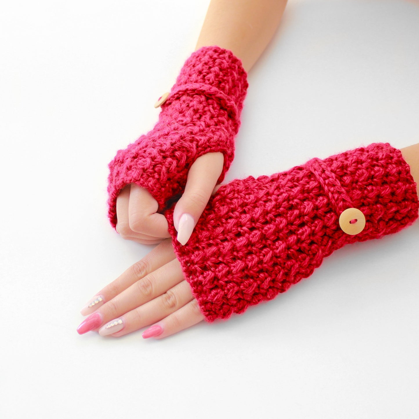May include: A pair of red crocheted fingerless gloves with a button on each wrist.