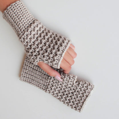 May include: A pair of beige crocheted fingerless gloves. The gloves are made with a textured stitch and have a simple, minimalist design.