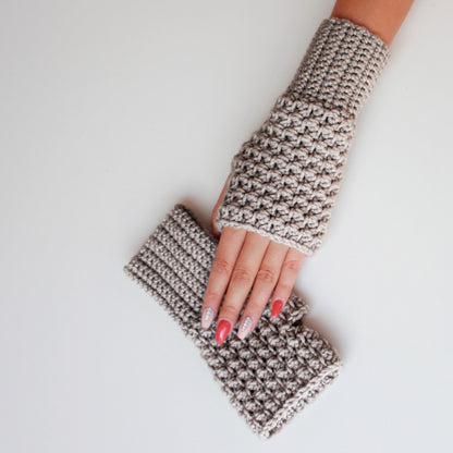 May include: A pair of beige crocheted fingerless gloves. The gloves are made with a textured stitch and are folded over at the wrist.