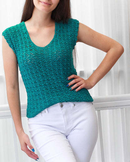 May include: A teal crochet top with a scoop neck and short sleeves. The top is made of a lightweight, open-weave fabric.