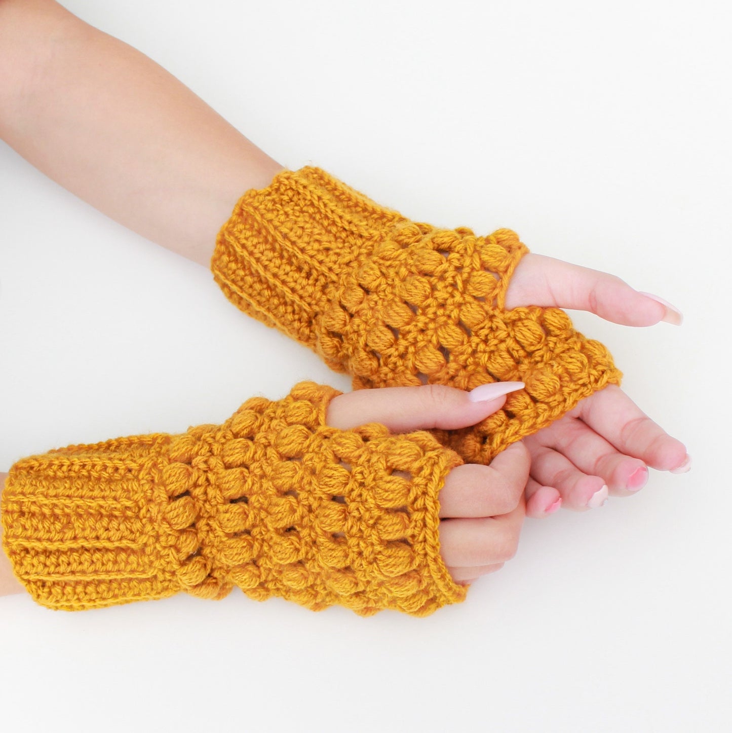 May include: A pair of yellow crocheted fingerless gloves with a textured, puffy design.