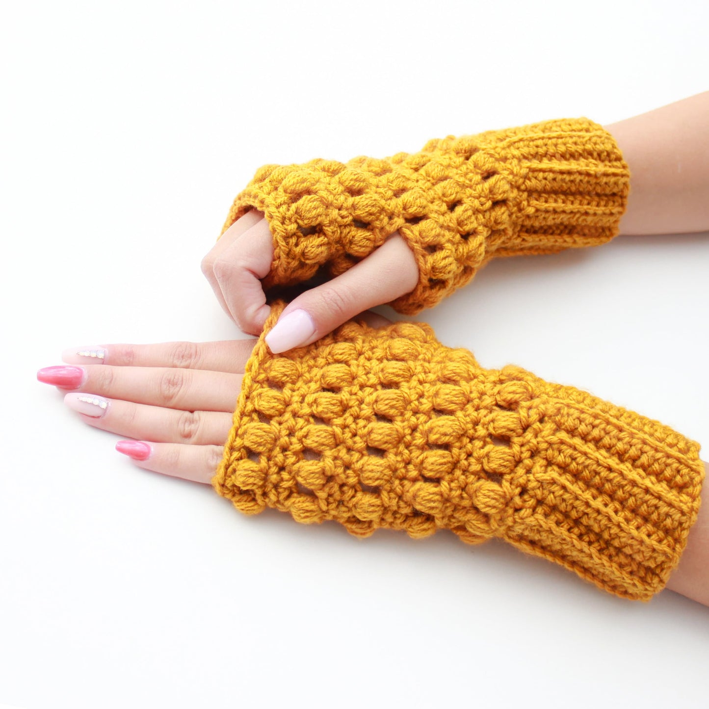 May include: A pair of yellow crocheted fingerless gloves with a textured design.