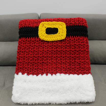 May include: A red and white crocheted blanket with a black and yellow belt. The blanket is designed to look like Santa Claus's suit.