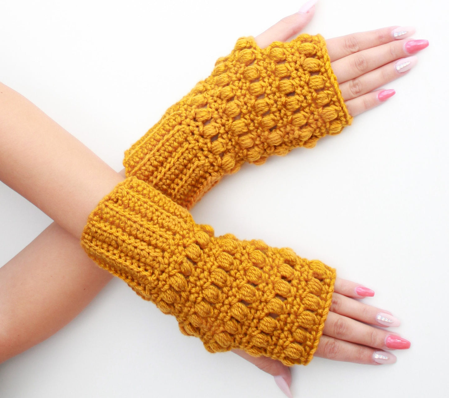 May include: A pair of yellow crocheted fingerless gloves with a textured, puffy design.