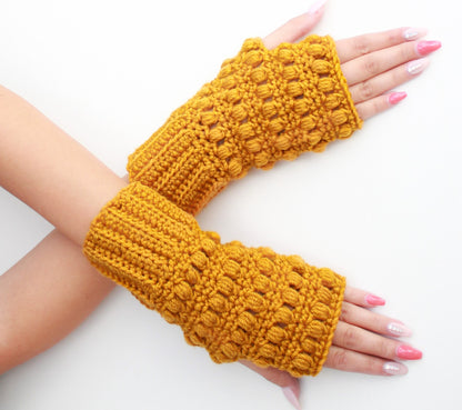 May include: A pair of yellow crocheted fingerless gloves with a textured, puffy design.