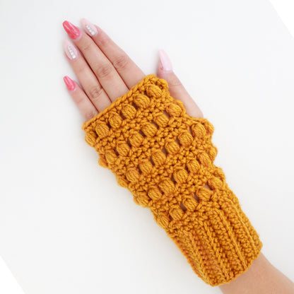 May include: A pair of mustard yellow fingerless gloves with a crocheted texture. The gloves have a textured pattern with small holes throughout.