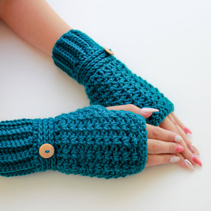 May include: A pair of teal blue crocheted fingerless gloves with wooden buttons. The gloves are shown on a white background.