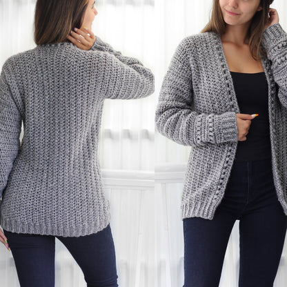 May include: A gray crocheted cardigan with a V-neck and long sleeves. The cardigan is shown on a model wearing black pants.