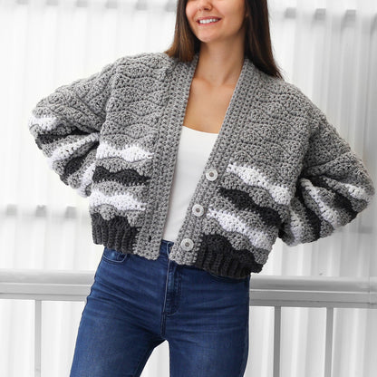 May include: A gray, white, and black striped cardigan with a button closure. The cardigan has a relaxed fit and a cropped length.