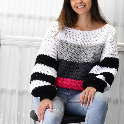 May include: A white, gray, black, and pink striped crocheted sweater with long sleeves and a wide neckline.