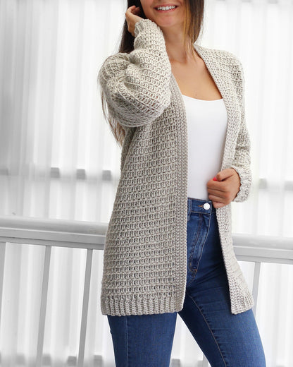 May include: A light gray crocheted cardigan with a long, open front and long sleeves. The cardigan is made with a textured stitch pattern.