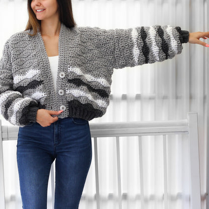 May include: A gray and white striped crocheted cardigan with a button closure. The cardigan has a relaxed fit and is cropped at the waist.