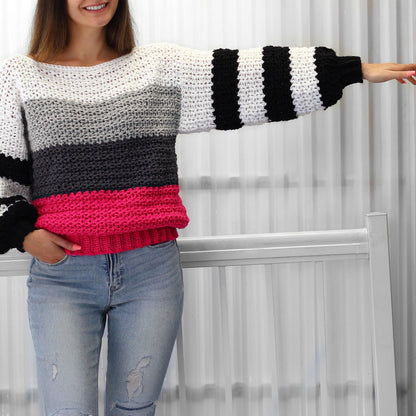 May include: A striped crochet sweater with a white, gray, black, and pink color scheme. The sweater has long sleeves with a wide, striped cuff. The sweater is made with a chunky yarn and has a relaxed fit.