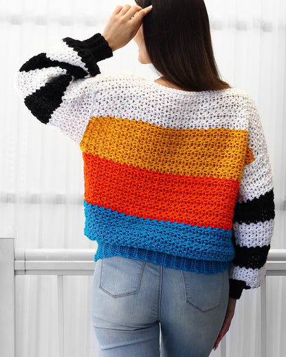 May include: A colorful striped crochet sweater with black and white stripes on the sleeves. The sweater is made with a variety of colors, including white, yellow, orange, red, and blue.