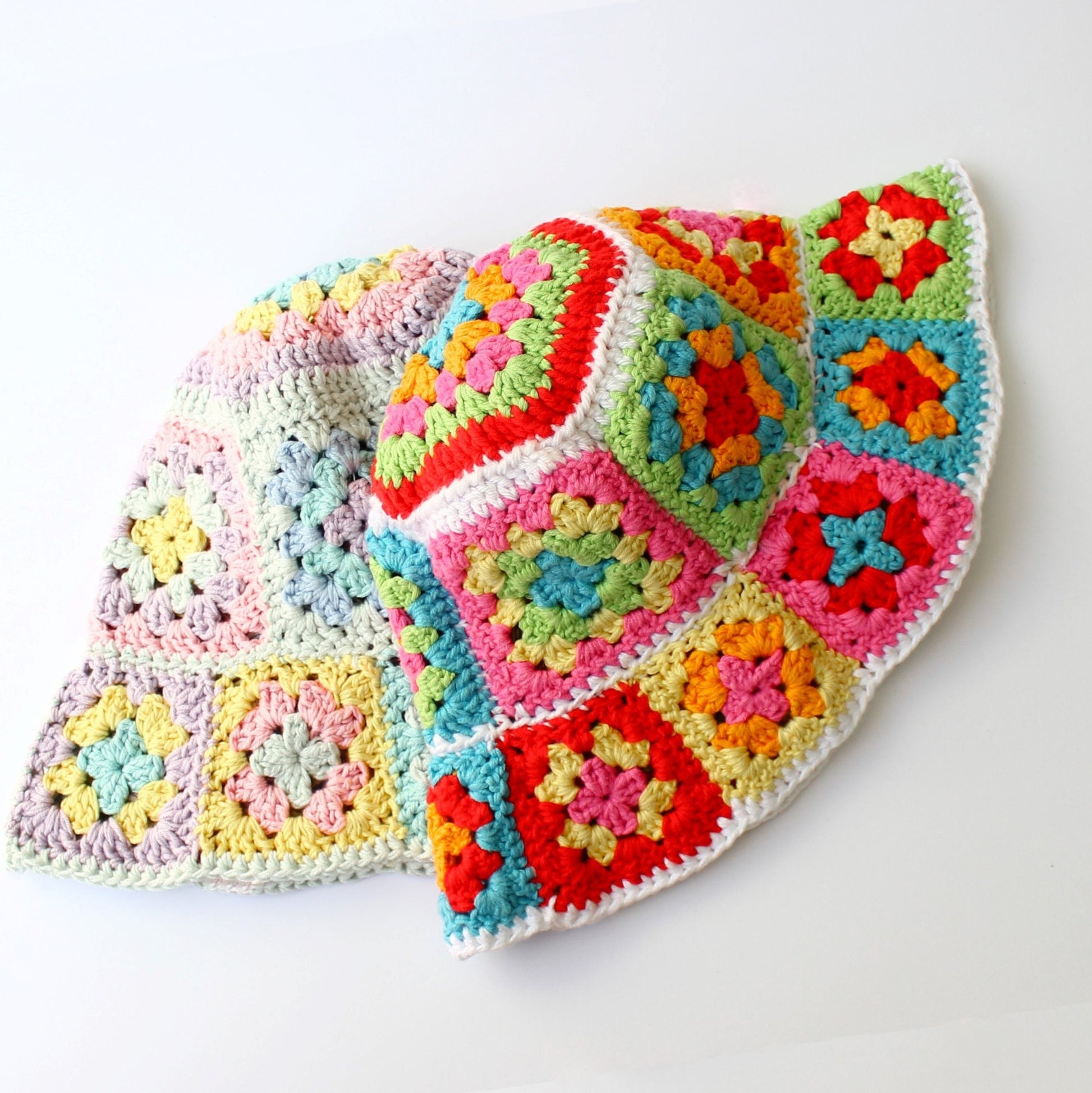 May include: A colorful crocheted sun hat with a wide brim. The hat is made of granny squares in shades of pink, yellow, green, blue, and red.