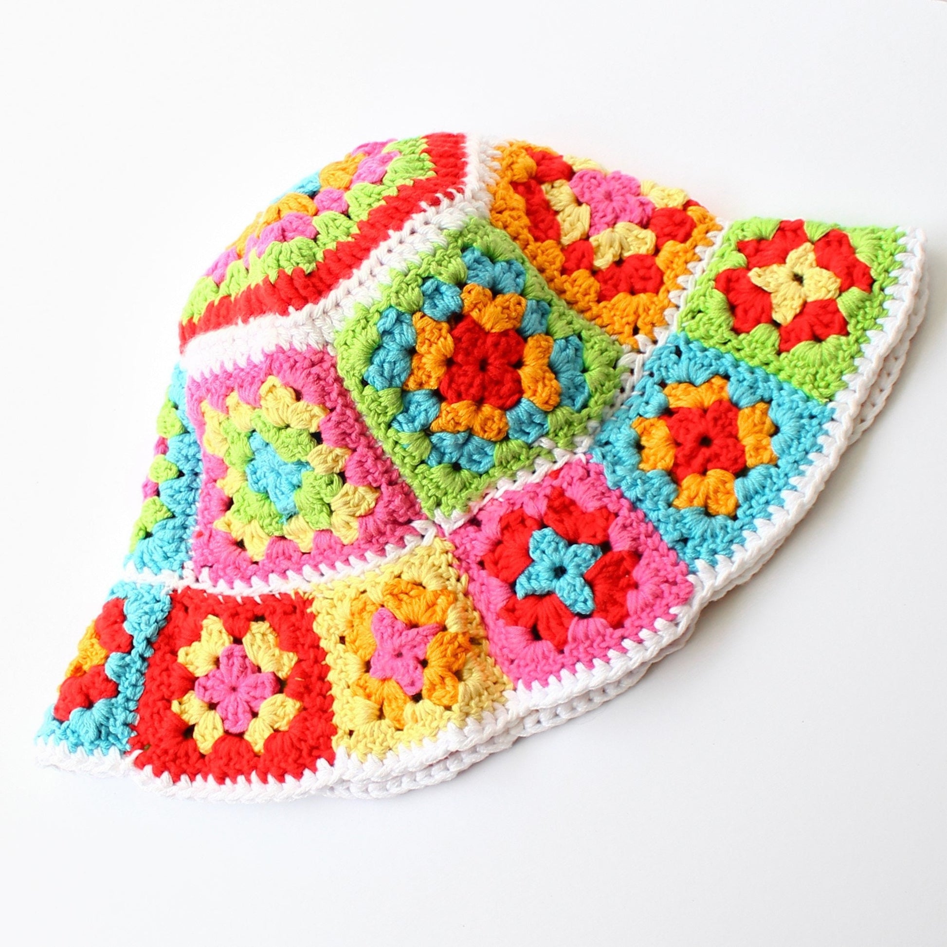 May include: A colorful crocheted sun hat with a wide brim. The hat is made of granny squares in shades of pink, red, orange, yellow, green, blue, and white.