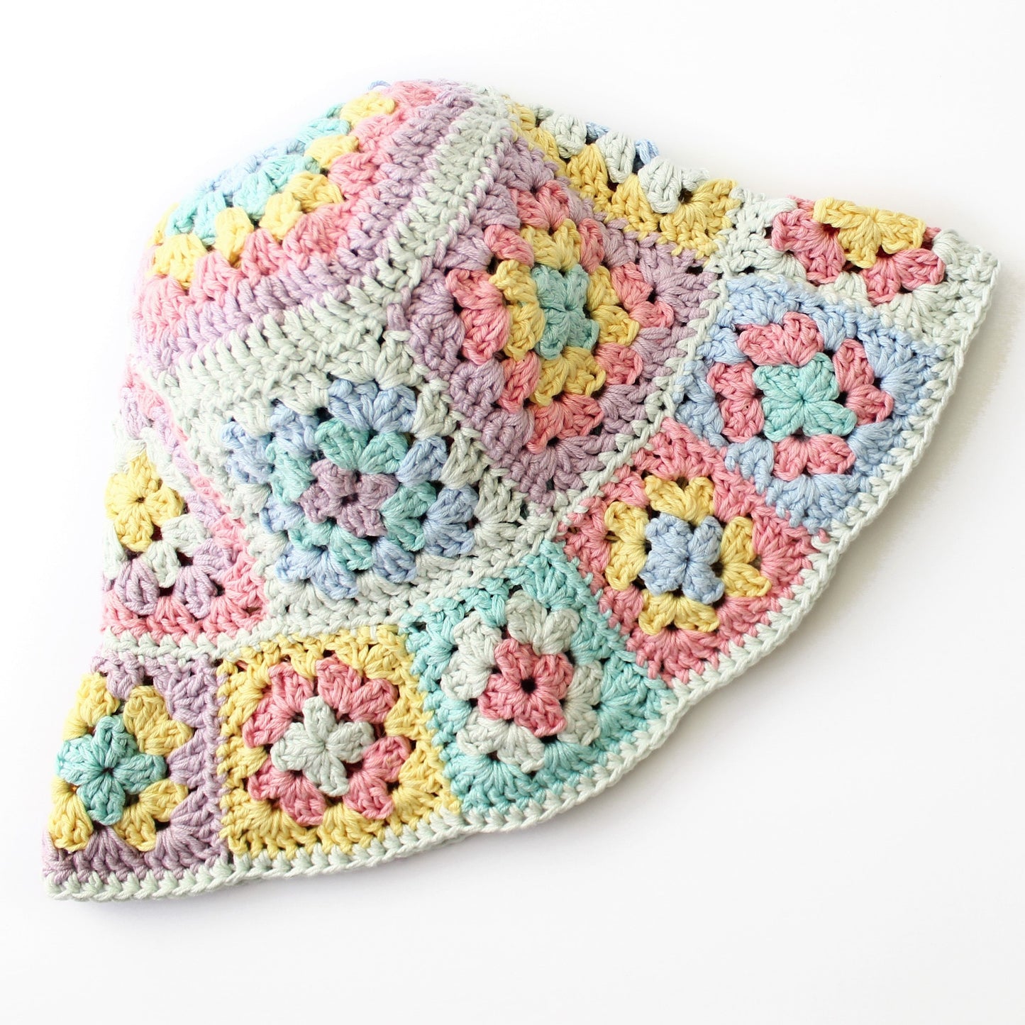 May include: A crocheted hat with a granny square pattern in pastel colors, including pink, blue, yellow, and green.