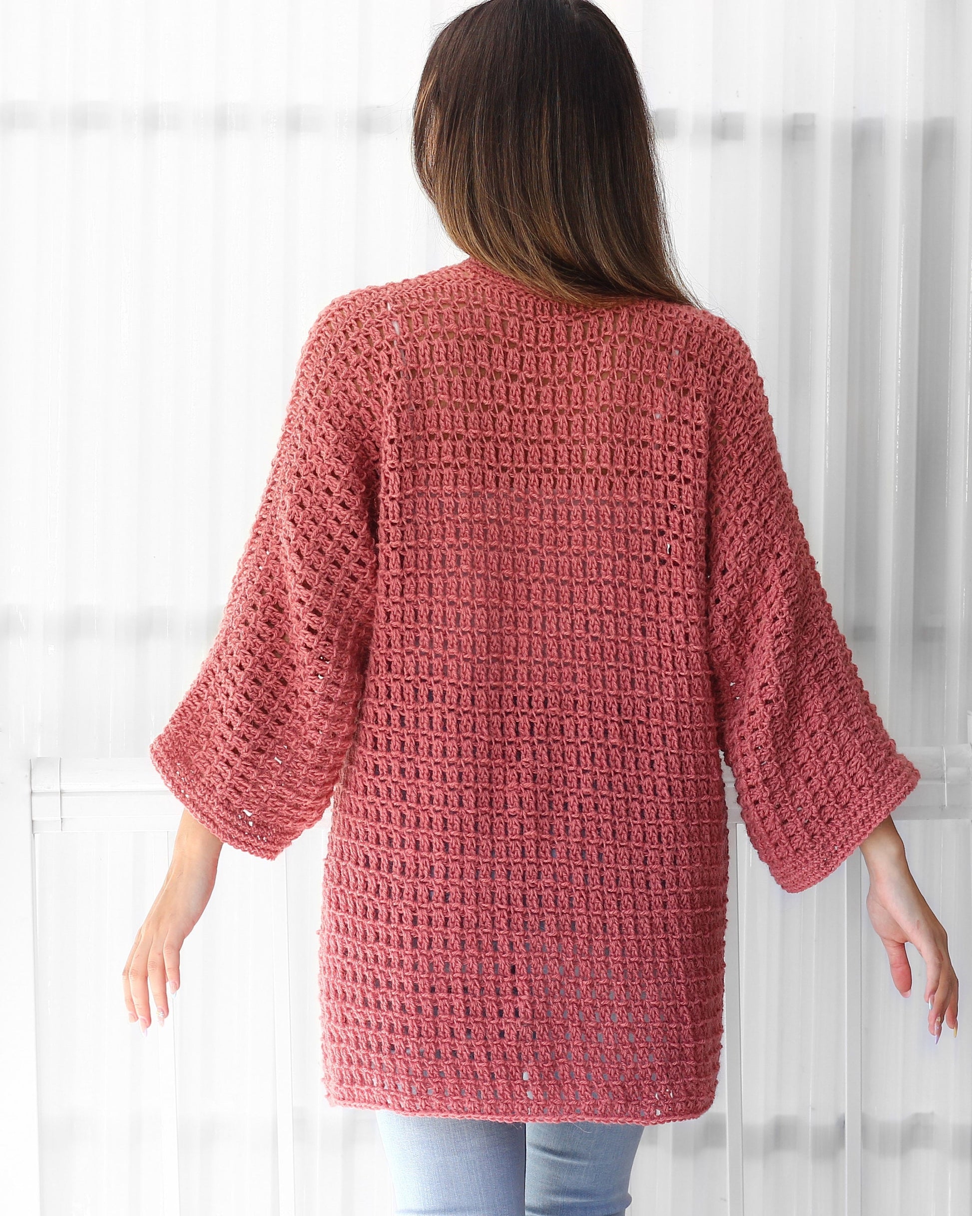 May include: A pink crocheted cardigan with a loose fit and 3/4 sleeves.