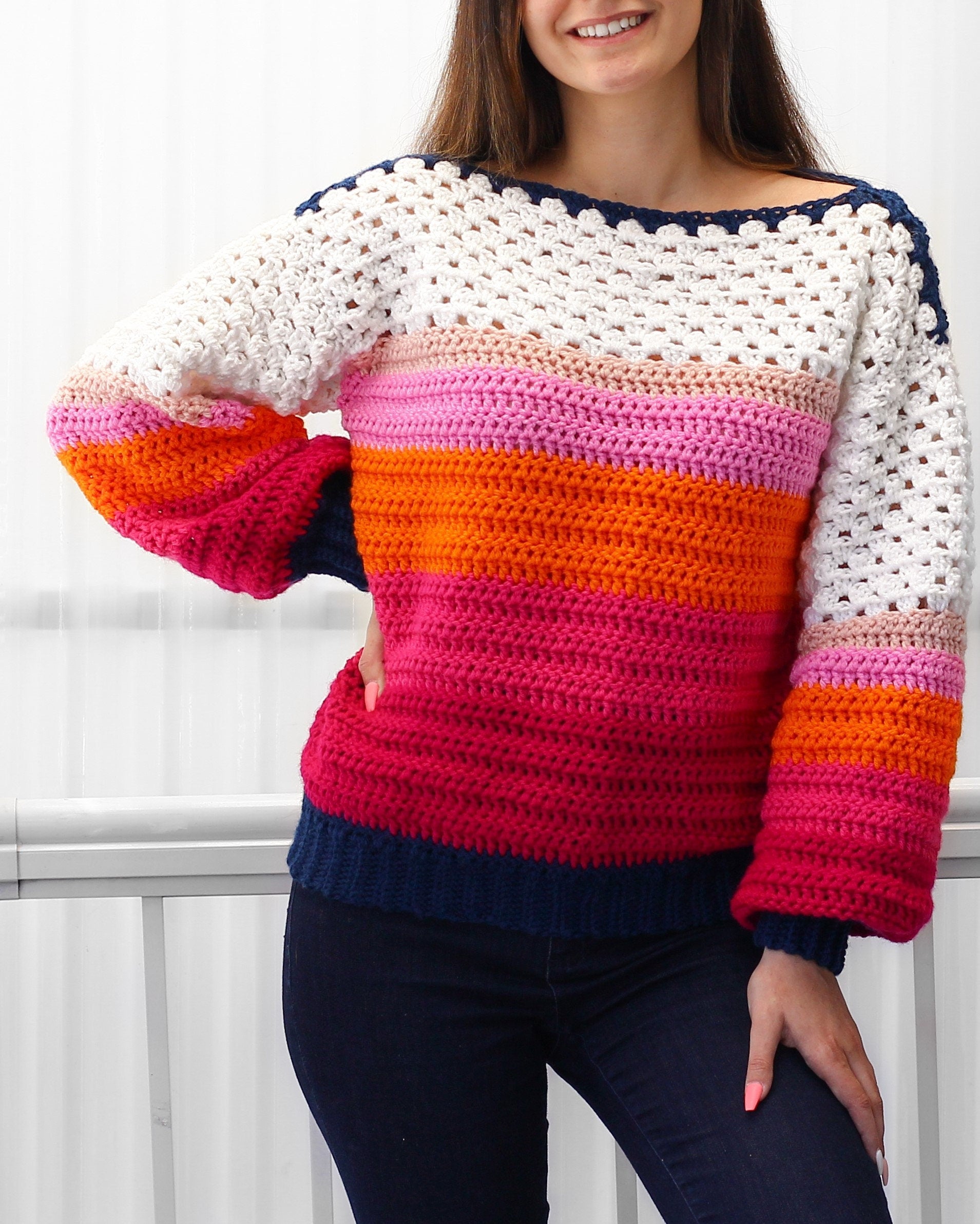 May include: A colorful striped crochet sweater with a white crocheted neckline and long sleeves. The sweater is made with a variety of colors, including pink, orange, and blue.