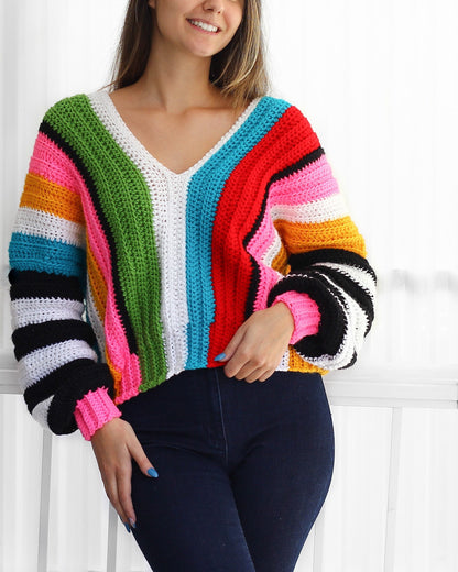 May include: A colorful striped crochet sweater with long sleeves and a V-neck. The sweater features a rainbow of colors, including red, orange, yellow, green, blue, and pink.