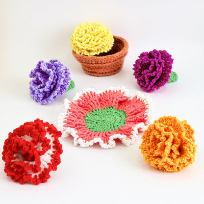 May include: A set of crocheted flowers in various colors, including red, yellow, orange, purple, and pink. The flowers are arranged on a white surface, with a crocheted flower pot in the background.
