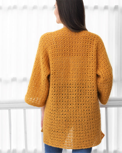 May include: A mustard yellow crochet cardigan with a loose fit and long sleeves.