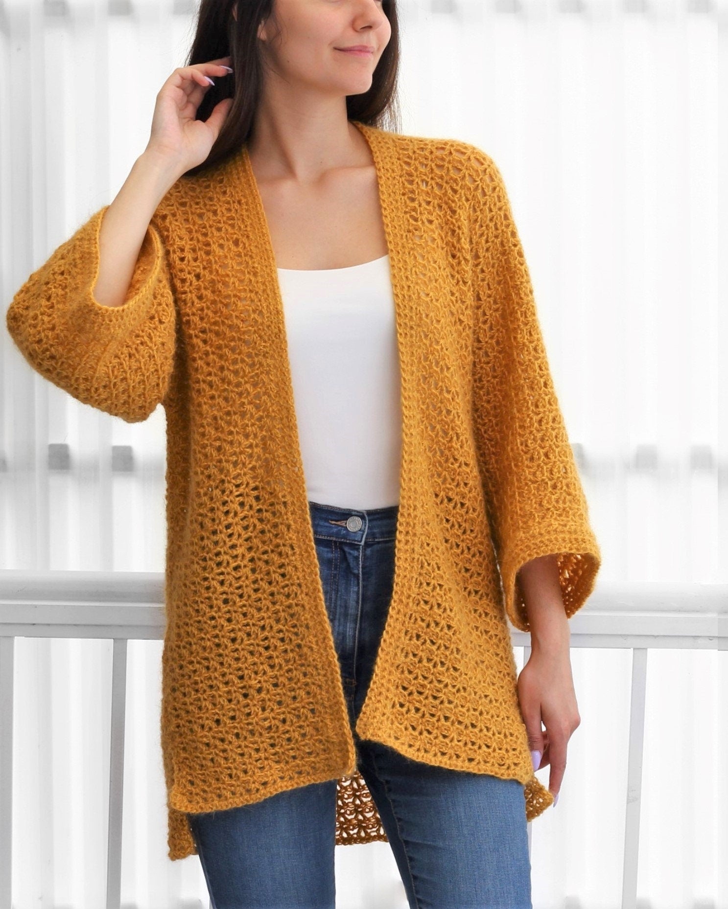 May include: A mustard yellow crochet cardigan with a loose fit and 3/4 sleeves.