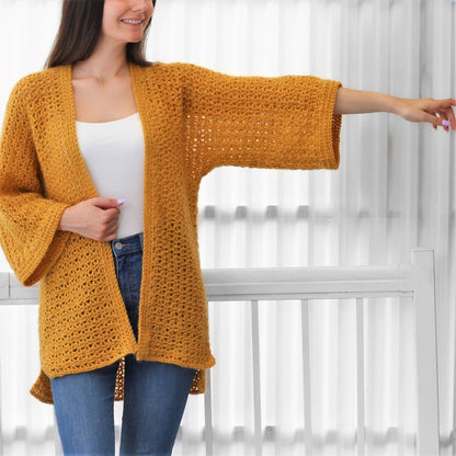 May include: A mustard yellow crochet cardigan with a loose fit and long sleeves. The cardigan is open in the front and has a delicate stitch pattern.
