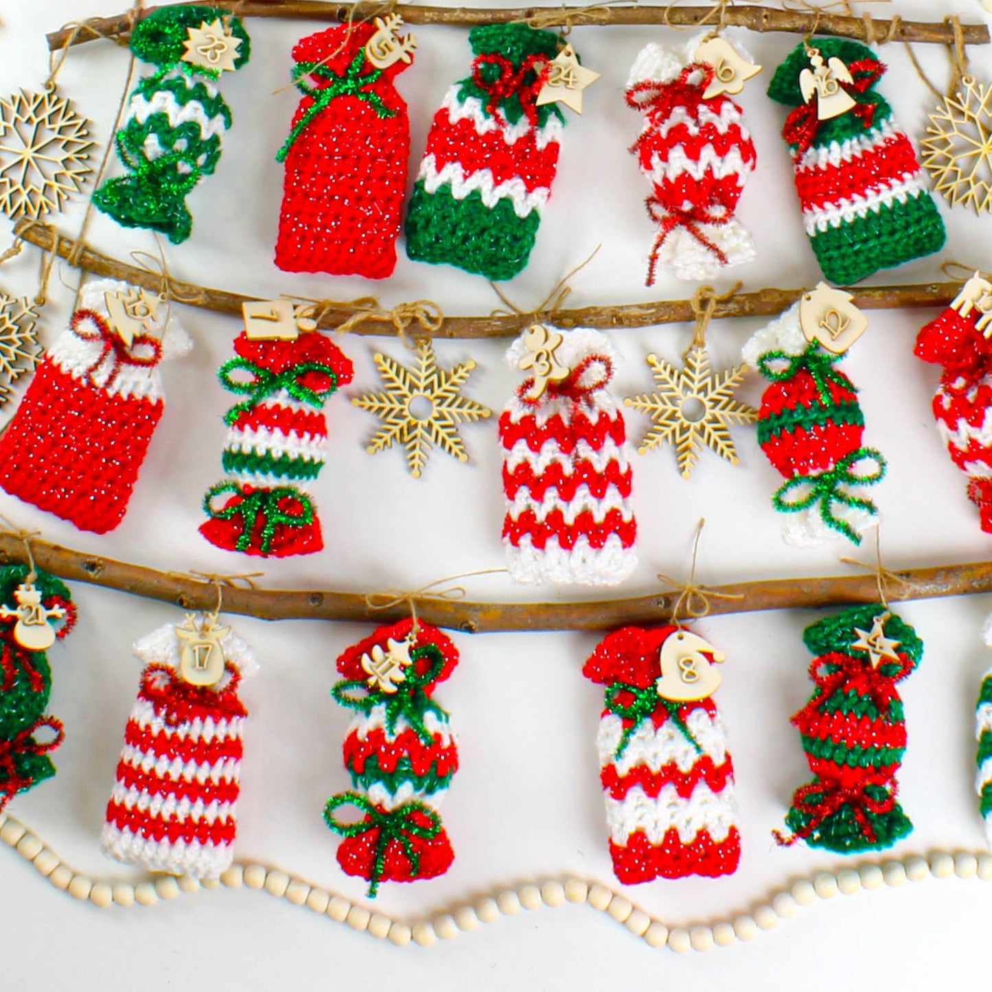 May include: A Christmas advent calendar made of crocheted red, white, and green candy cane ornaments with numbers 1 through 24 hanging from a branch.
