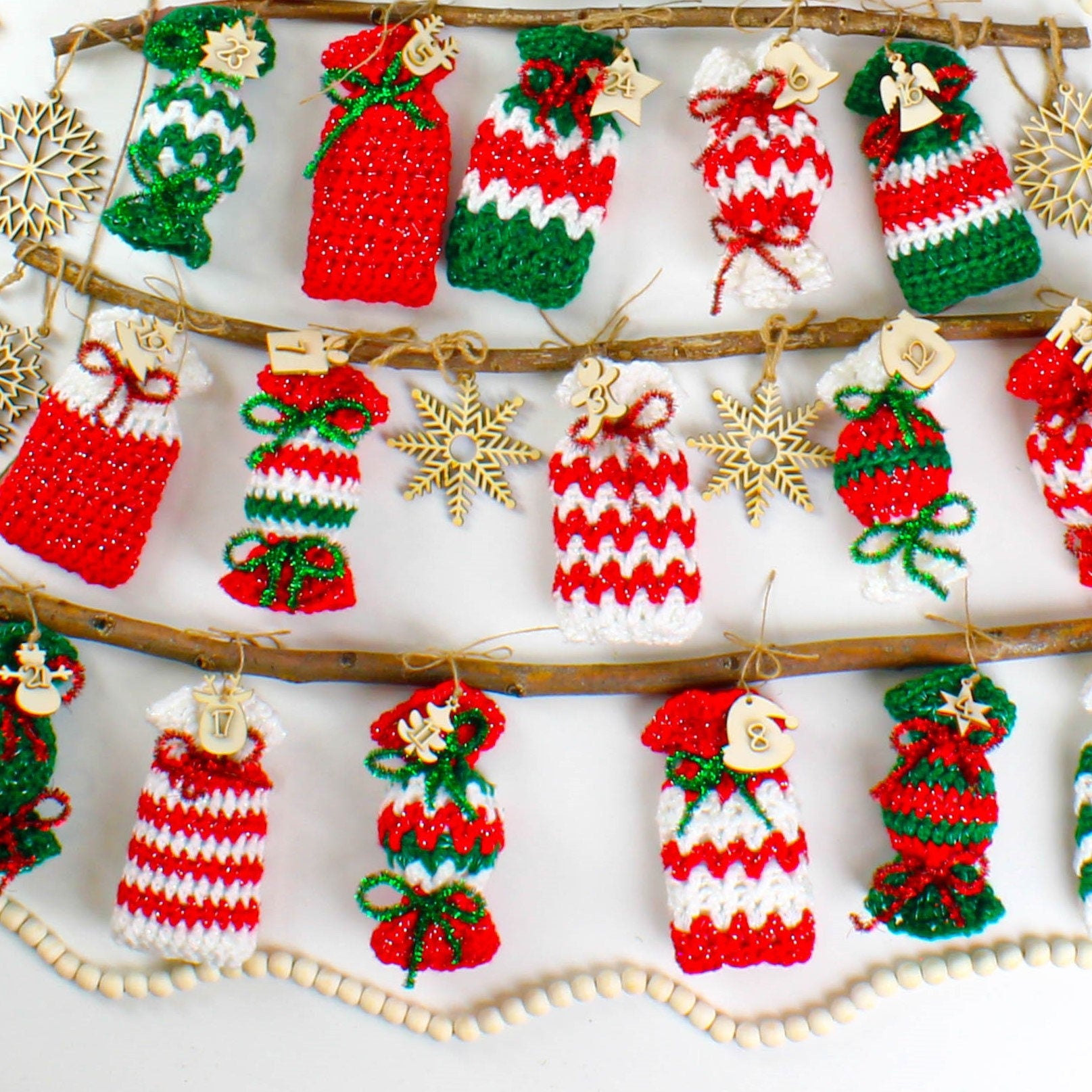 May include: A Christmas advent calendar made of crocheted red, white, and green candy cane ornaments with numbers 1 through 24 hanging from a branch.