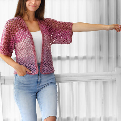 May include: A pink and white crochet cardigan with a loose fit and short sleeves.
