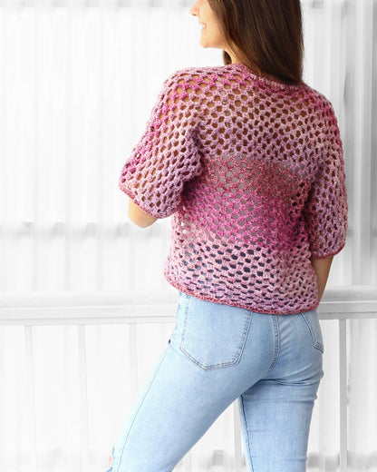 May include: A pink and purple crochet top with a loose, open-weave design. The top has short sleeves and a relaxed fit.