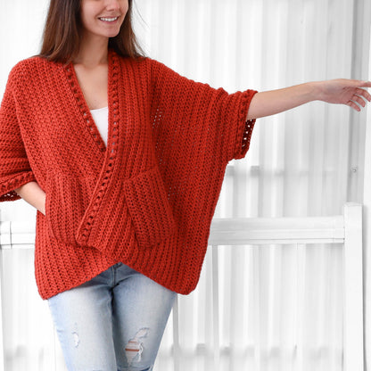 May include: A red crocheted cardigan with a V-neck and pockets. The cardigan has a crocheted trim around the neckline and sleeves.