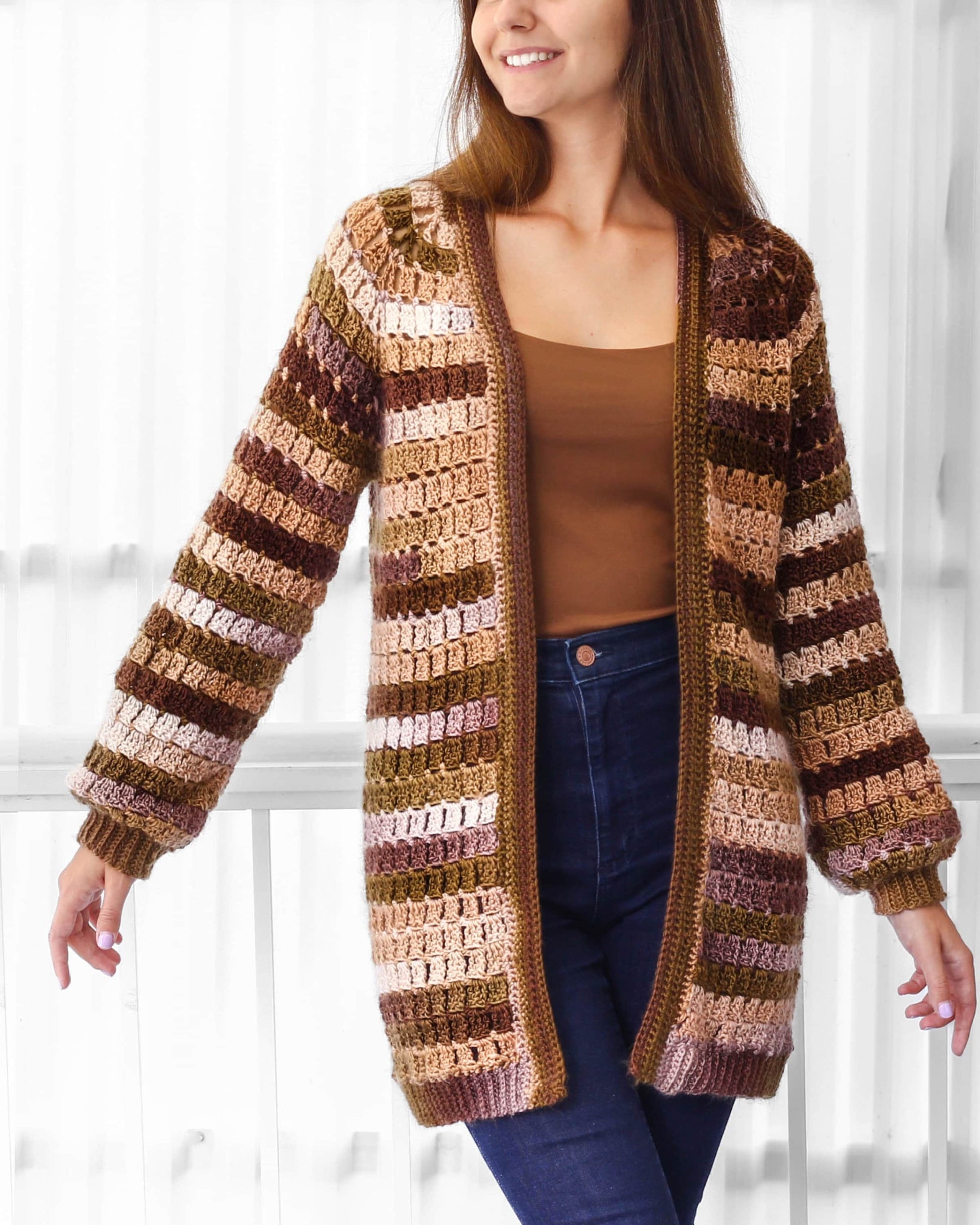 May include: A long, brown, beige, and green striped crochet cardigan with a V-neck and long sleeves.